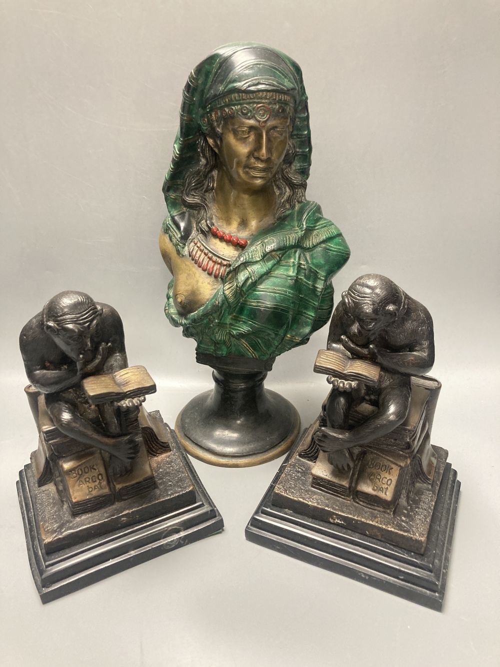 A pair of bronze monkey bookends and a cold painted bronze bust of a Nubian lady, height 32cm